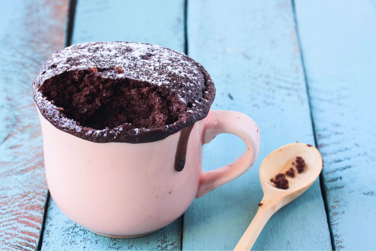 Mug chocolate cake on a wooden surface.