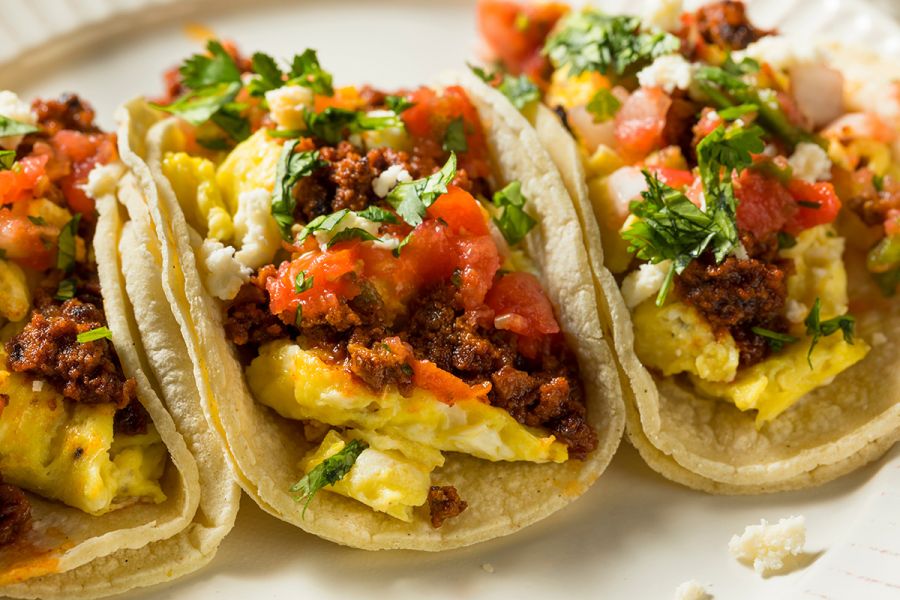Three home made breakfast tacos with chorizo sausage and egg.