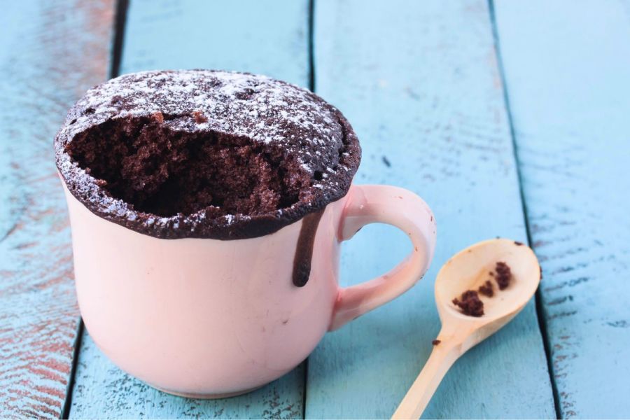 Mug chocolate cake on a wooden surface.