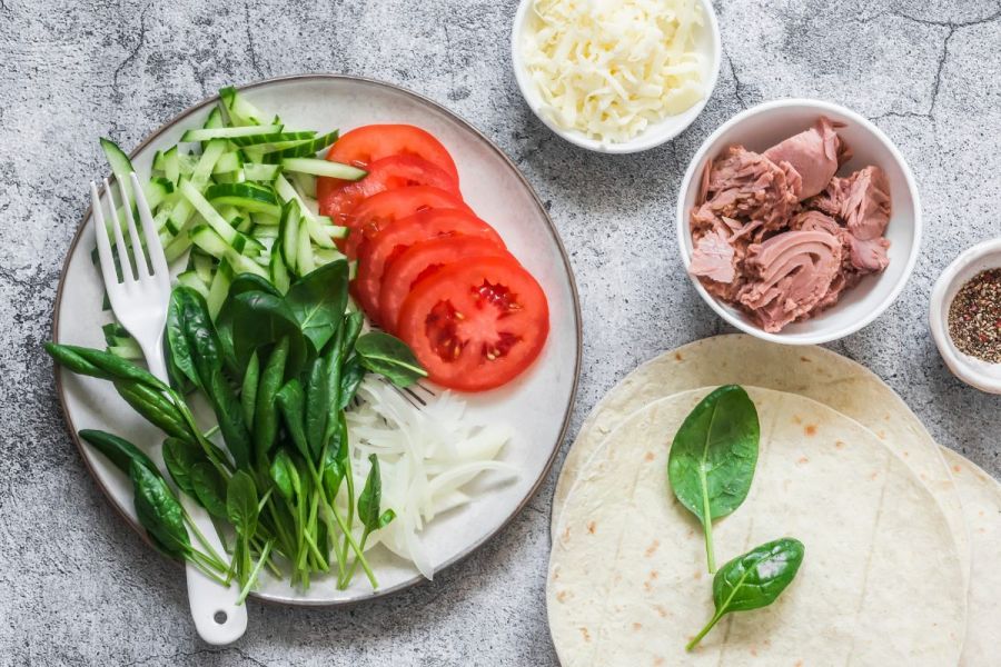 A spread of ingredients to make tuna quesadillas on a kitchen countertop.